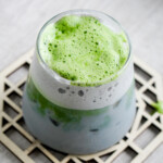 black sesame matcha latte angled shot of matcha foam and glass tumbler