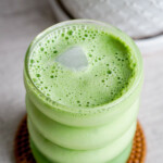 creamy matcha latte showing ice peeking out of the foam on top