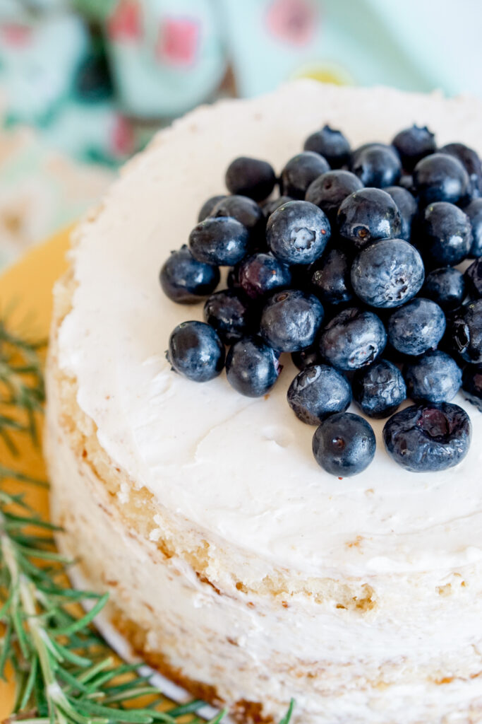 6" three layer lemon naked cake with blueberries on top and rosemary on the side