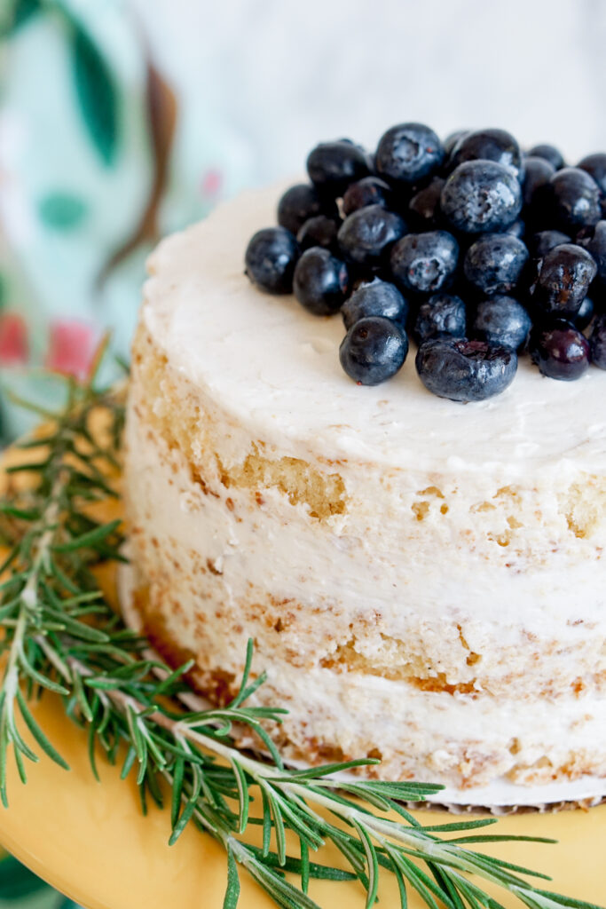 6" three layer lemon naked cake with blueberries on top and rosemary on the side