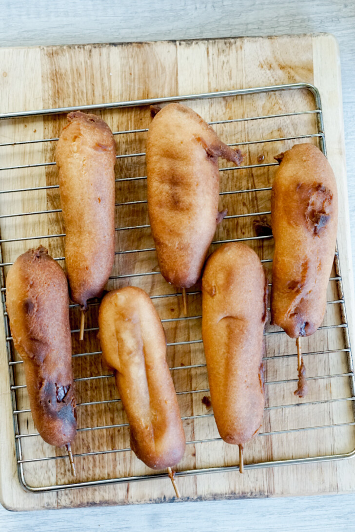 6 andagi dog cooling on a wire rack over a cutting board