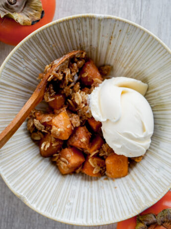 overhead shot of persimmon crisp in a Japanese ceramic bowl with vanilla ice cream