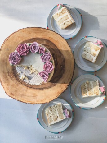 lychee cake with wreath of buttercream flowers showing three layer slices