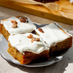 three slices of carrot cake butter mochi with whipped cream cheese frosting