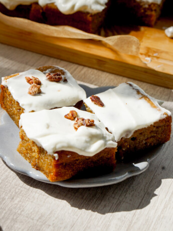 three slices of carrot cake butter mochi with whipped cream cheese frosting