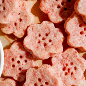 strawberry shortbread cookie dough cut in cherry blossom shape overhead shot of pile