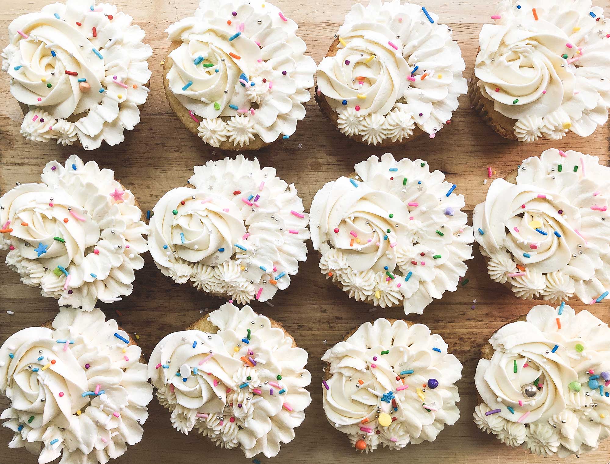 Overhead, cupcakes with white frosting.